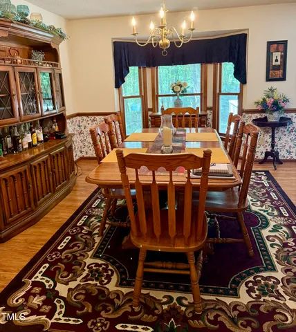 a view of a dining room with furniture wooden floor and chandelier