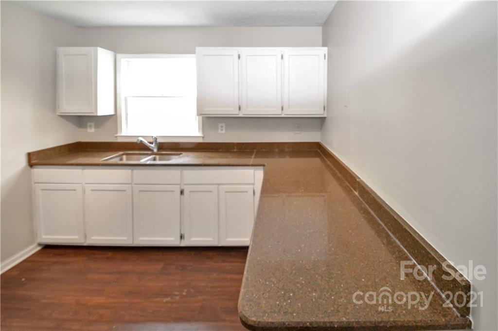 2433 State Rd S-46-172, Unit 3 Clover, SC 29710 - Photo 7 of 22 a kitchen with granite countertop white cabinets and sink