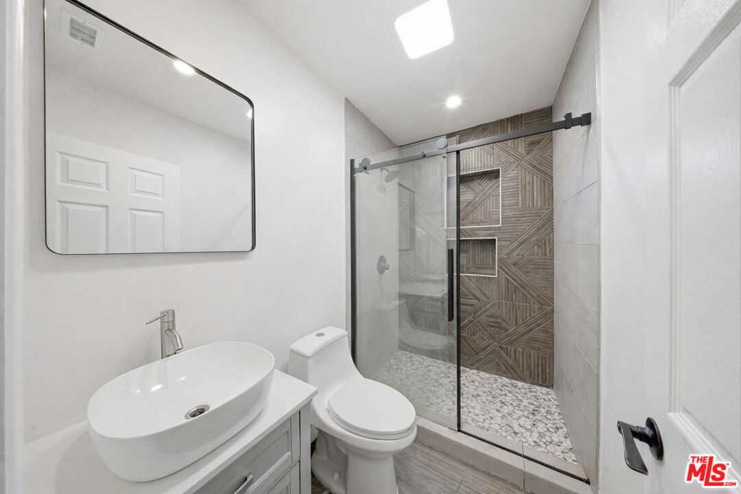 20237 Hartland Street Winnetka, CA 91306 - Photo 7 of 13 a bathroom with a toilet sink and a shower