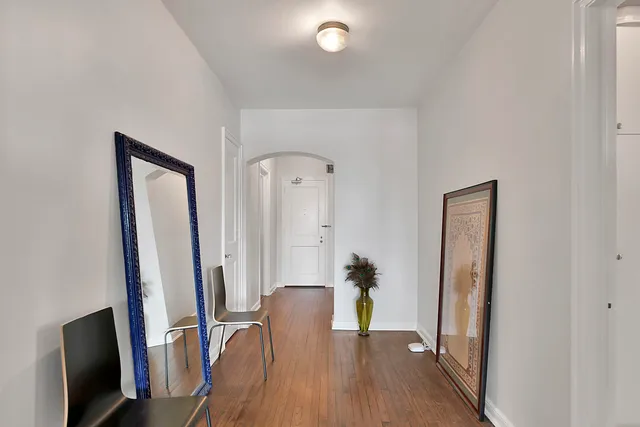 a view of a hallway with wooden floor and furniture
