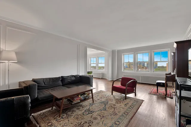 a living room with furniture a rug a lamp and a window
