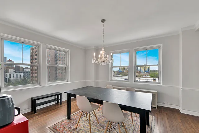 a dining room with furniture a chandelier and wooden floor