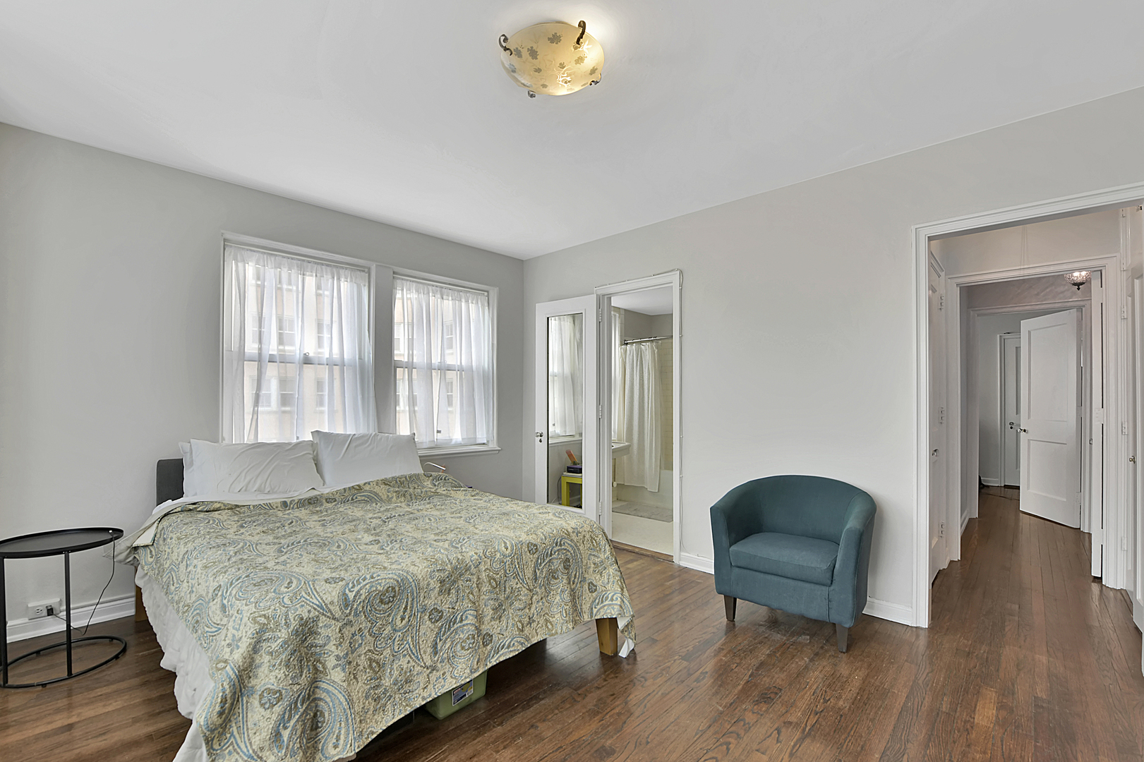 5555 North Sheridan Road, Unit 507 Chicago, IL 60640 - Photo 10 of 15 a spacious bedroom with a bed and a chandelier