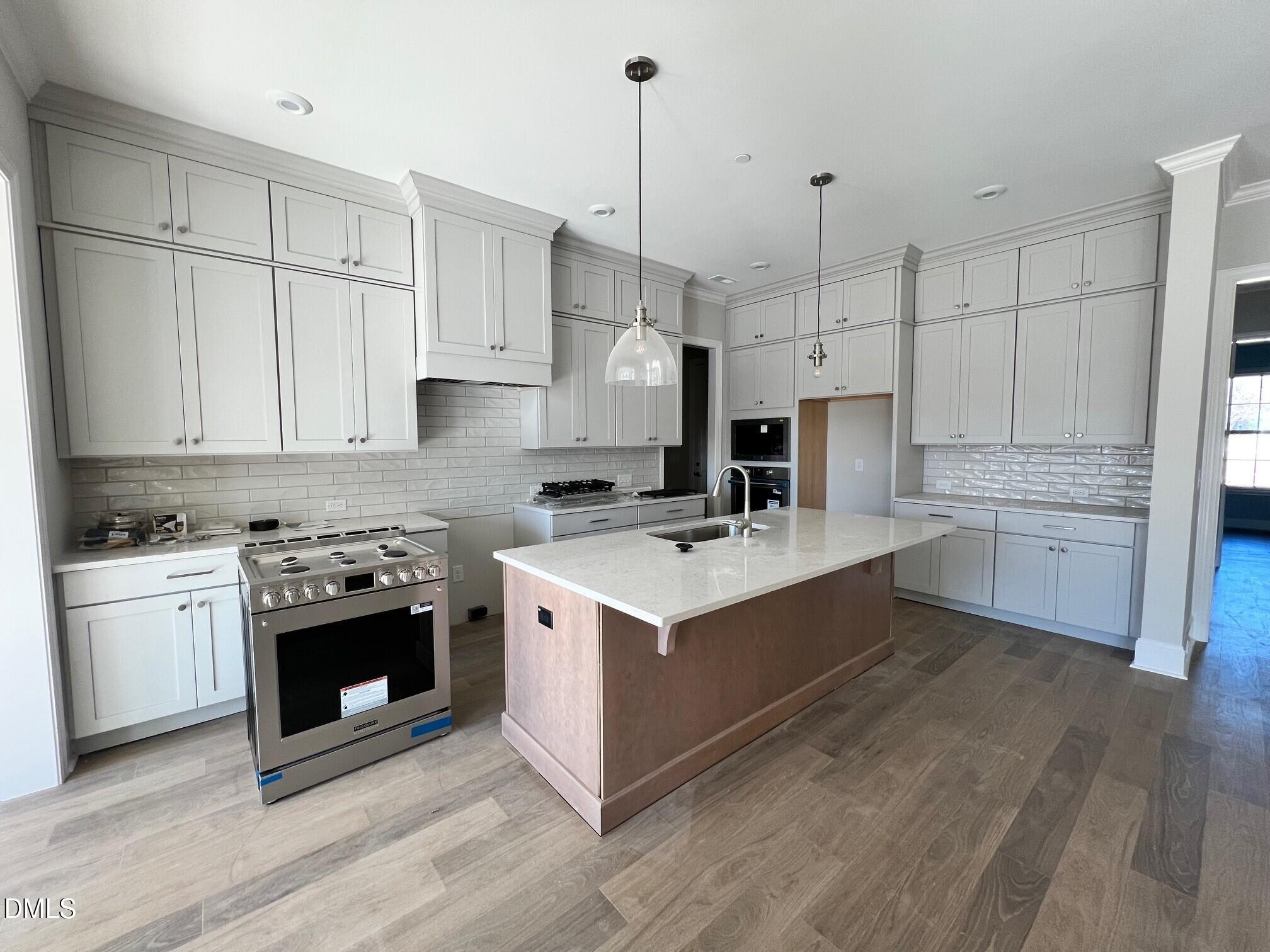 1003 Coldspring Circle Durham, NC 27705 - Photo 7 of 24 a kitchen with stainless steel appliances granite countertop a stove oven and white cabinets