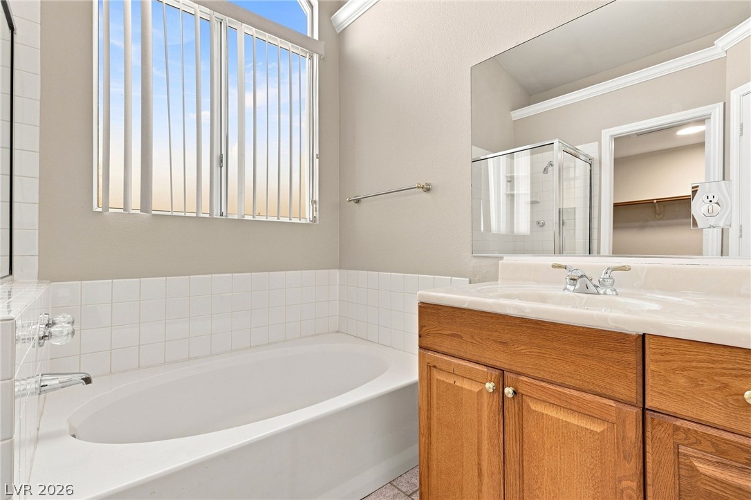 904 Shadowfax Road Henderson, NV 89015 - Photo 15 of 31 High ceilings and a deep soaking tub highlight this relaxing bathroom space.