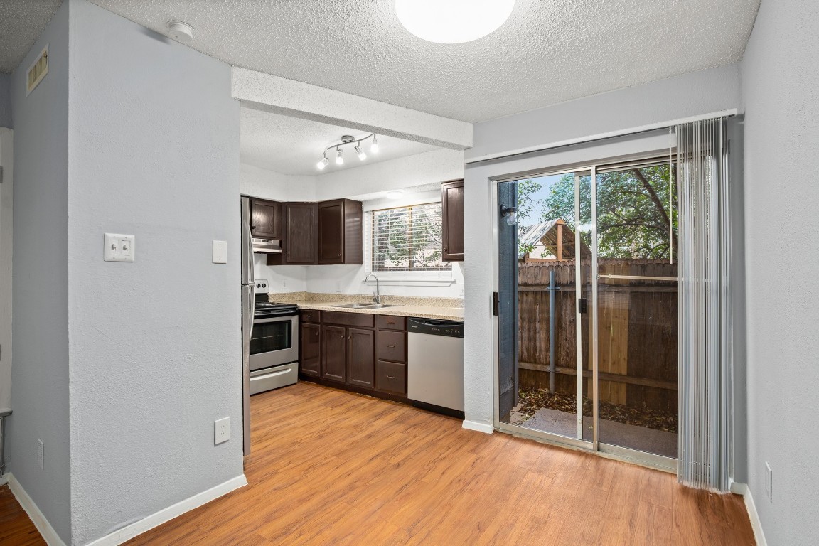 a kitchen with stainless steel appliances granite countertop a refrigerator and a sink