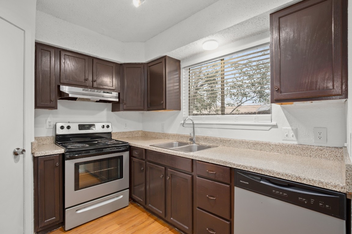 3415 Menchaca Road, Unit 101 Austin, TX 78704 - Photo 5 of 14 a kitchen with granite countertop cabinets stainless steel appliances and a sink