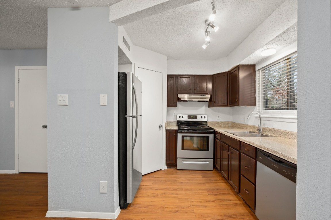 3415 Menchaca Road, Unit 101 Austin, TX 78704 - Photo 6 of 14 a kitchen with stainless steel appliances granite countertop refrigerator a sink a stove top oven and a dishwasher next to a window