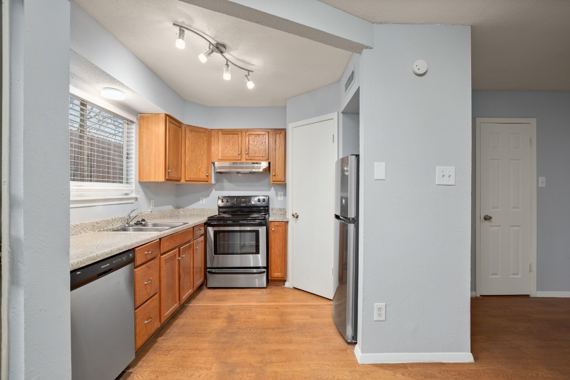 3415 Menchaca Road, Unit 101 Austin, TX 78704 - Photo 8 of 14 a kitchen with stainless steel appliances granite countertop a stove and a refrigerator
