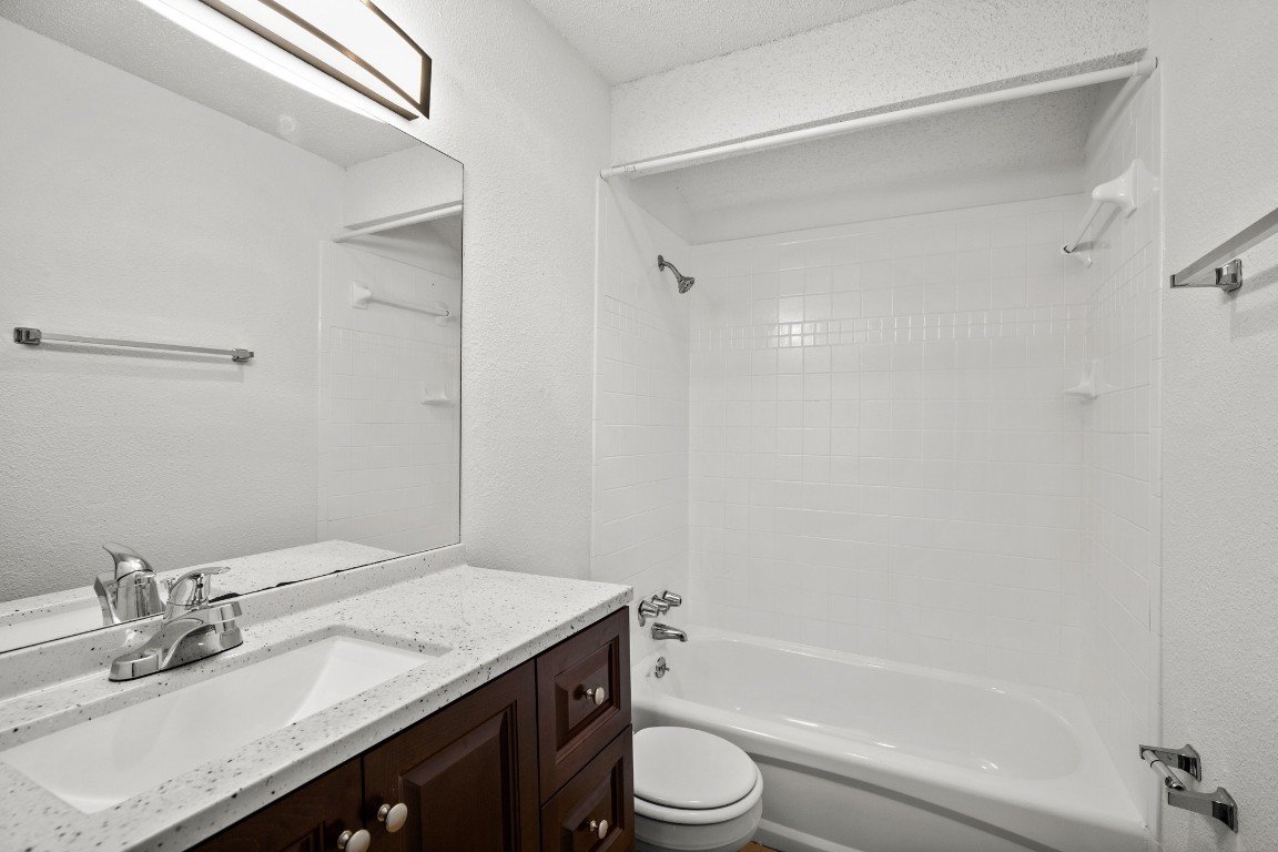 3415 Menchaca Road, Unit 101 Austin, TX 78704 - Photo 10 of 14 a bathroom with a granite countertop sink toilet and shower