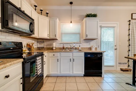 a kitchen with stainless steel appliances granite countertop a stove a sink and a microwave