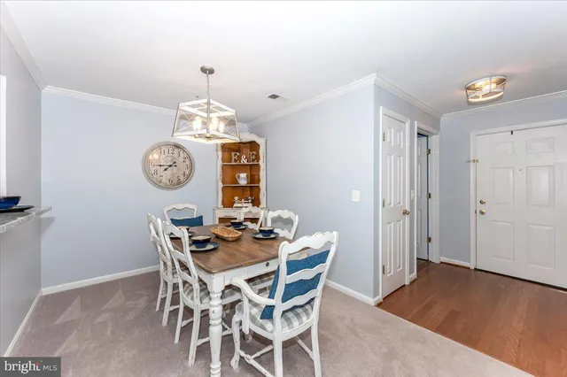 a dining room with furniture a chandelier and wooden floor