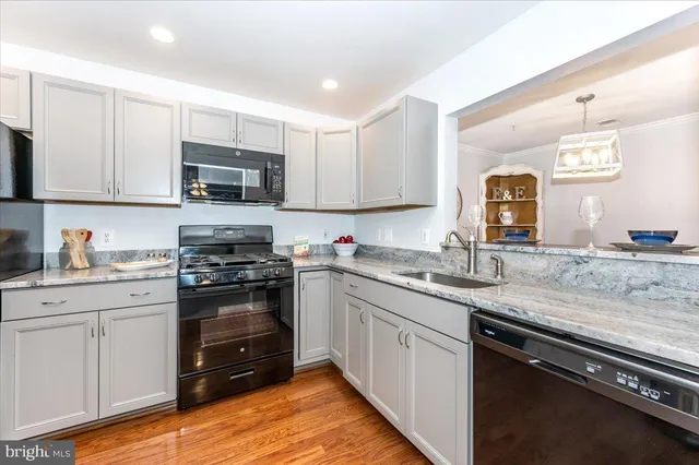 a kitchen with stainless steel appliances granite countertop a sink stove and cabinets