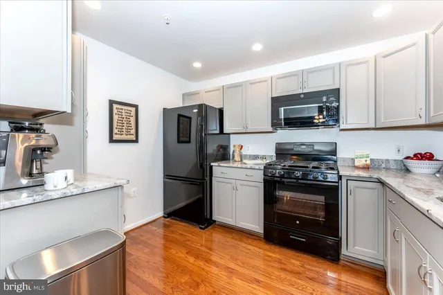 a kitchen with stainless steel appliances granite countertop a refrigerator stove and microwave