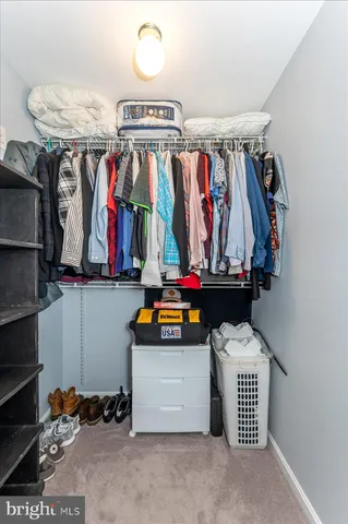 a view of walk in closet with clothes and shoes