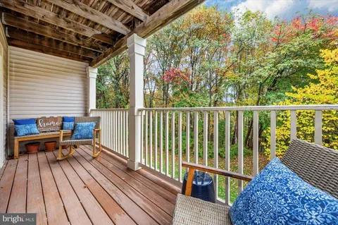 a view of a balcony with wooden floor and outdoor seating
