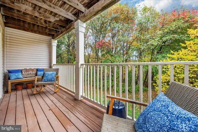 a view of a balcony with wooden floor and outdoor seating