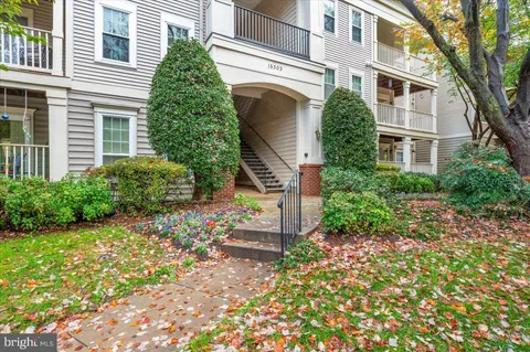 a front view of a house with a yard and potted plants