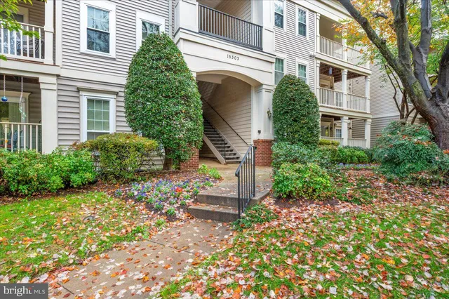 a front view of a house with a yard and potted plants