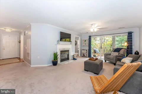 a living room with furniture a fireplace and a large window