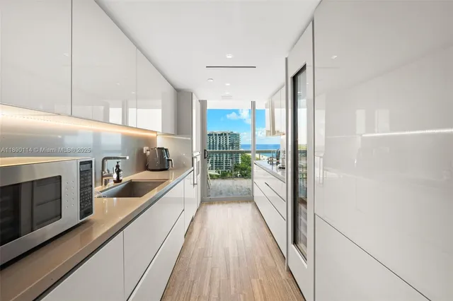 a view of a kitchen with a sink and wooden floor