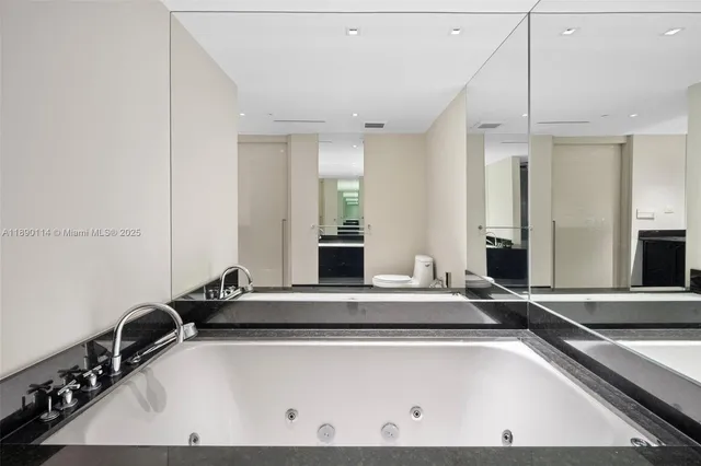 a room with a large bed and mirror