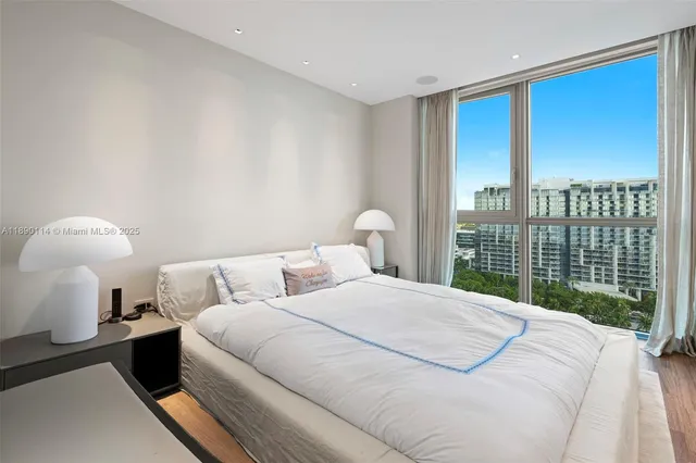 a bedroom with a large bed and a lamp next to a window