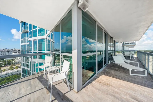 a view of a balcony with floor to ceiling windows and wooden fence