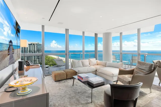 a living room with furniture and a floor to ceiling window
