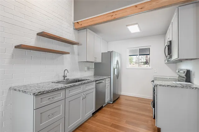 a kitchen with stainless steel appliances granite countertop a sink stove and refrigerator