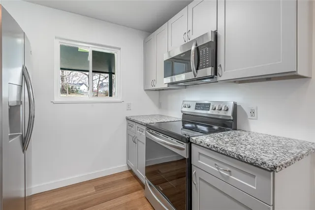 a kitchen with stainless steel appliances granite countertop a stove microwave and sink