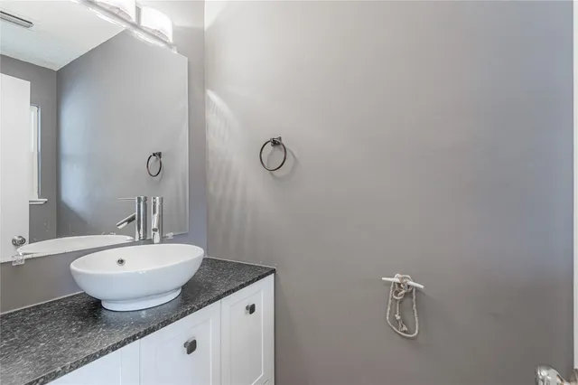a bathroom with a granite countertop sink and a mirror