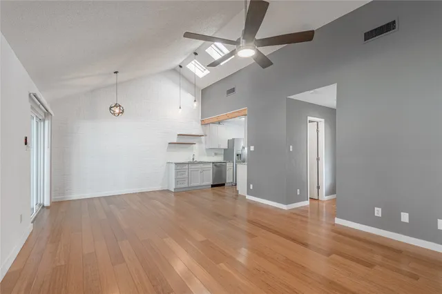a view of a kitchen with wooden floor a sink and a refrigerator