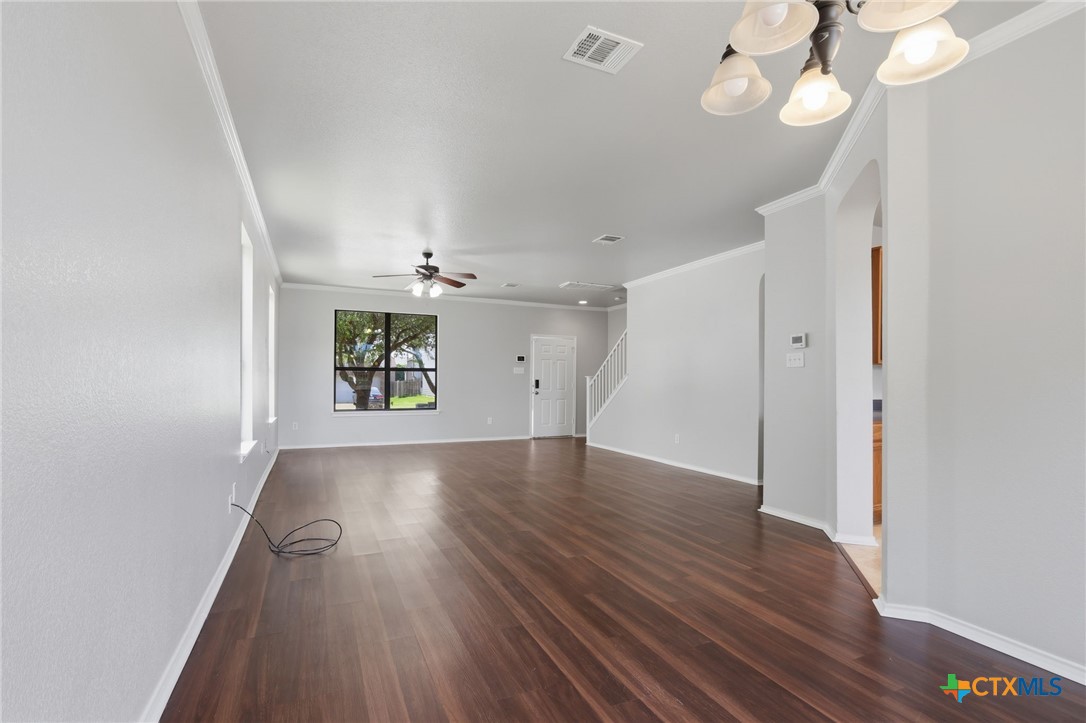 8716 Starview Street Temple, TX 76502 - Photo 6 of 36 Bright and open living space featuring rich dark flooring, light walls, a ceiling fan and with entry to the kitchen..