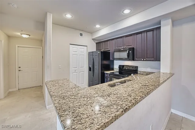 a kitchen with stainless steel appliances granite countertop a refrigerator and a sink