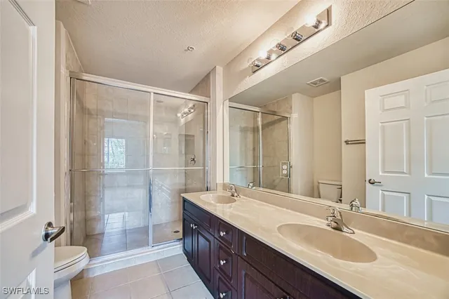 a spacious bathroom with a granite countertop sink mirror and shower