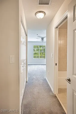 an empty room with a window and a fan