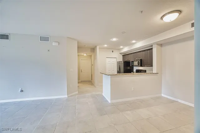 a view of kitchen with kitchen island stainless steel appliances refrigerator sink and cabinets