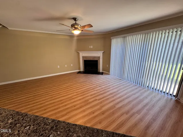 wooden floor in an empty room with a chandelier fan