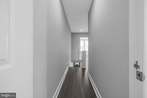 a view of a hallway with wooden floor and a carpet