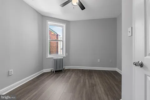 an empty room with a window and wooden floor