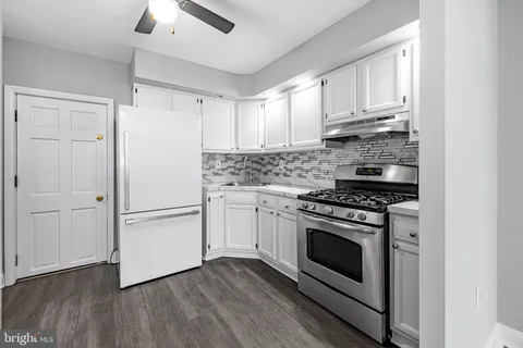a kitchen with cabinets appliances and wooden floor