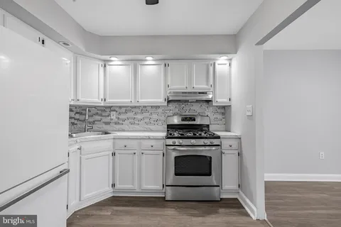 a kitchen with a stove oven and white cabinets