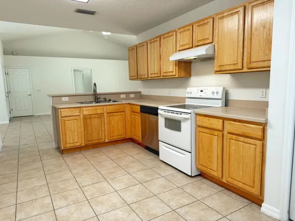 a kitchen with granite countertop white cabinets and white appliances