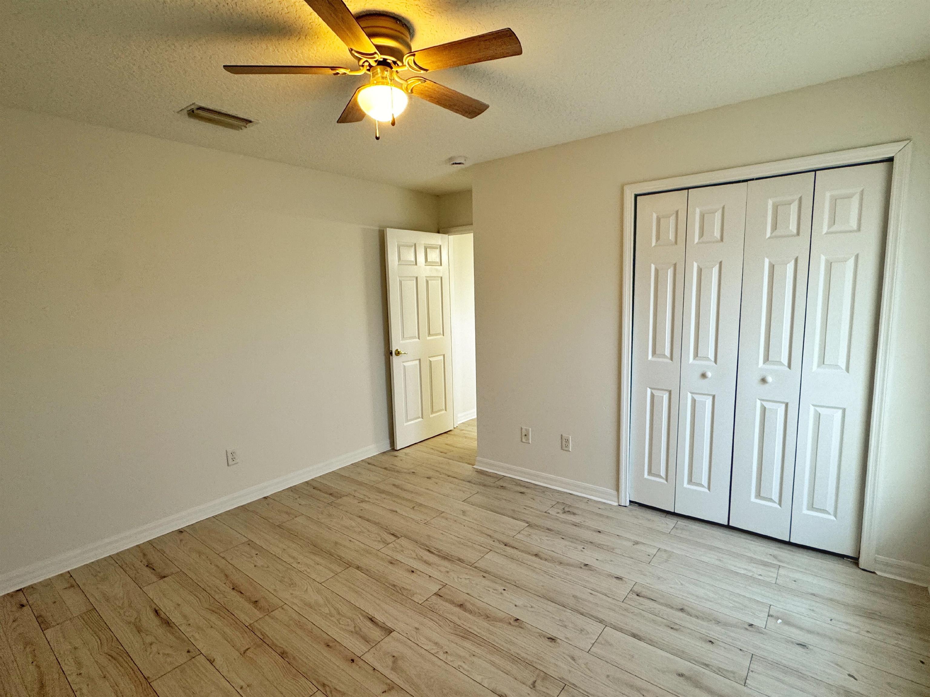 632 Segovia Road St. Augustine, FL 32086 - Photo 24 of 28 an empty room with wooden floor fan and windows