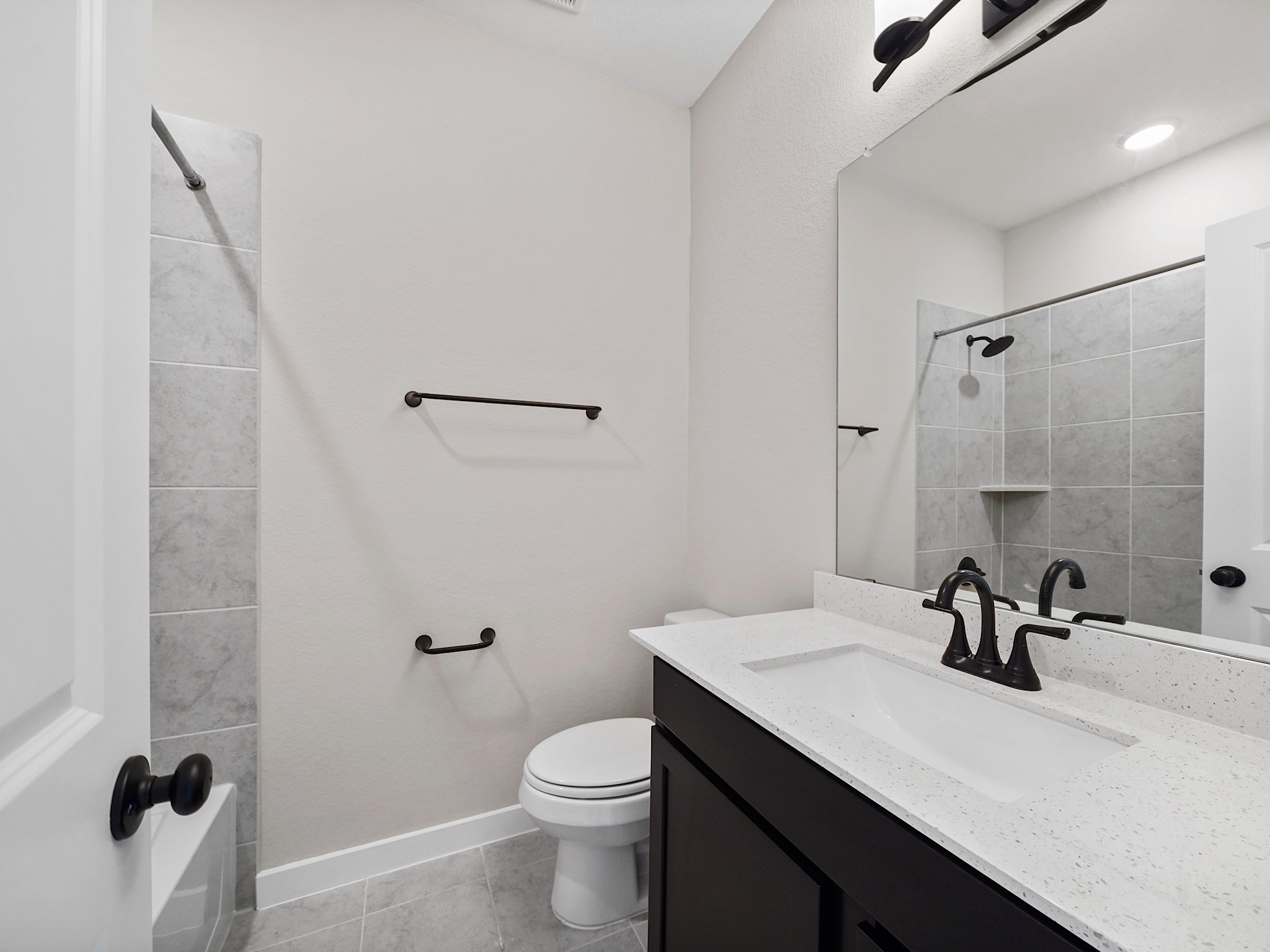 30214 Crossfield Road Fulshear, TX 77441 - Photo 31 of 42 Ensuite bath features a sleek dark vanity, black fixtures, and a tub/shower ombo.
