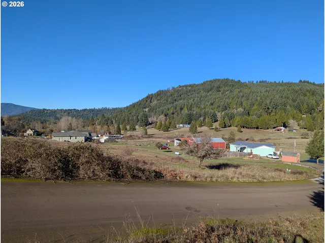a view of a rural road with mountains in the background