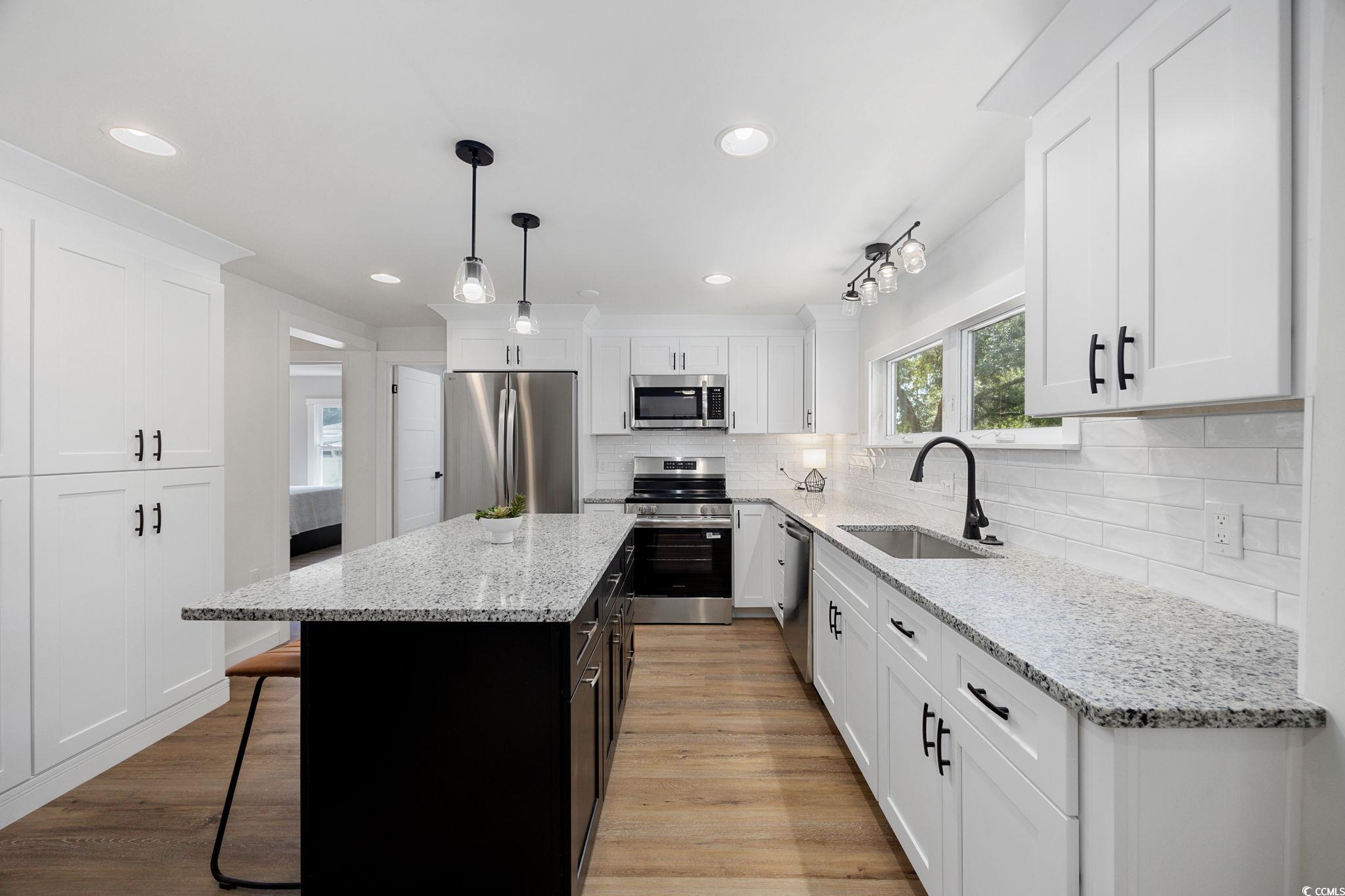 983 South Marlin Circle Murrells Inlet, SC 29576 - Photo 5 of 40 Kitchen featuring stainless steel appliances, white cabinets, light wood-type flooring, and recessed lighting