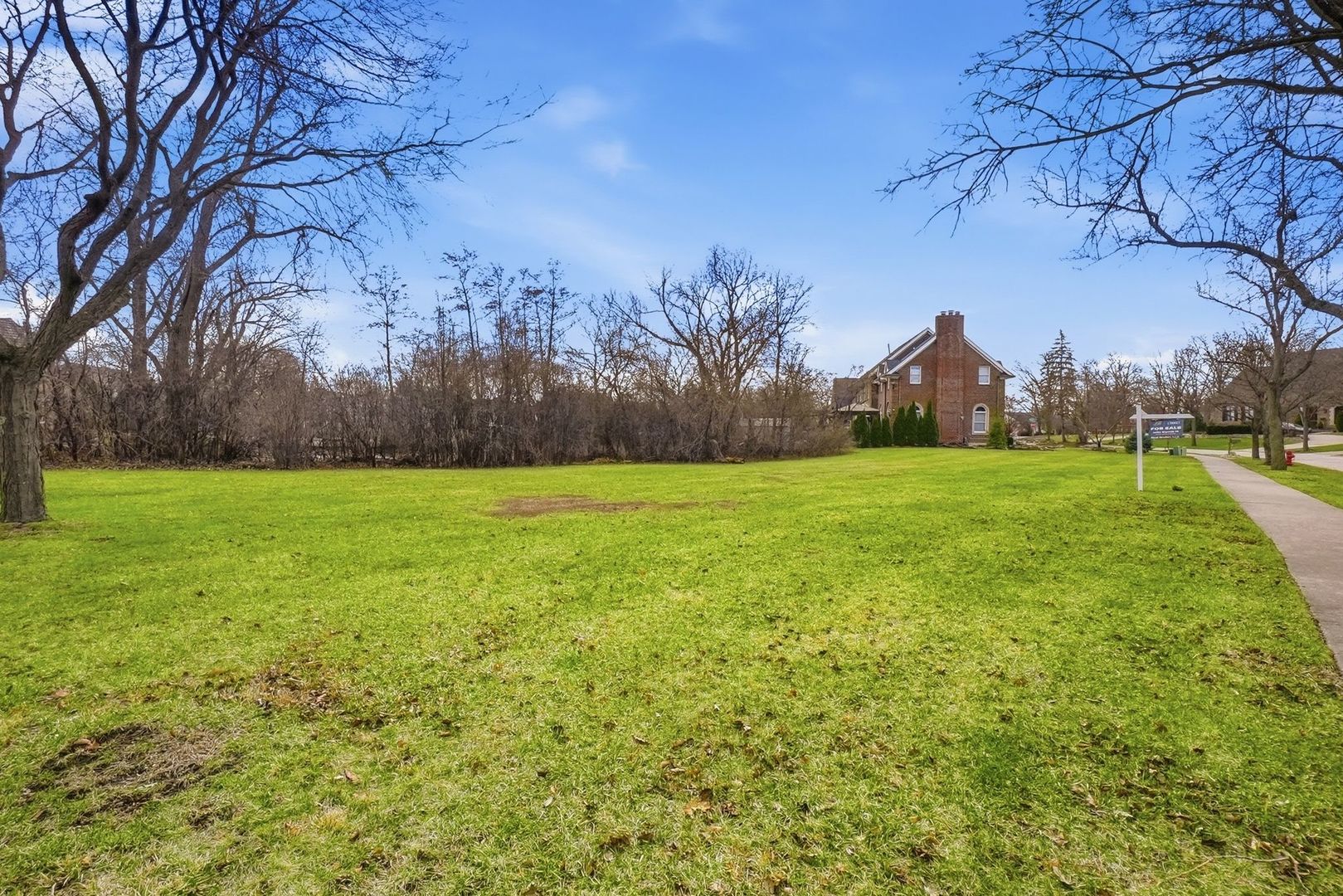 9045 Turnberry Drive Burr Ridge, IL 60527 - Photo 2 of 14 a view of a grassy field with trees in the background