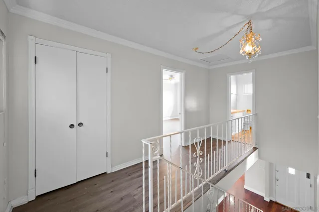 an empty room with chandelier fan and windows